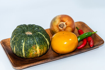 A bunch of grapes, pumpkin and chili on a white background.