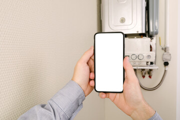 online diagnostics of household appliances via a mobile phone. a man repairing a boiler