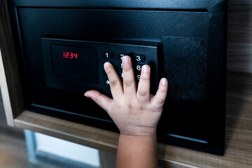 Kids inserting password small modern safe on shelf