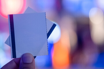 Hands holding an empty white a paper movie ticket.