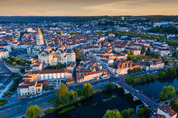Scenic summer landscape of Perigueux with medieval Catholic Cathedral on bank of Isle river at daybreak, France..