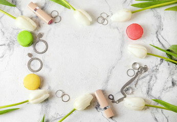 Frame made of female accessories, cookies and flowers on light background