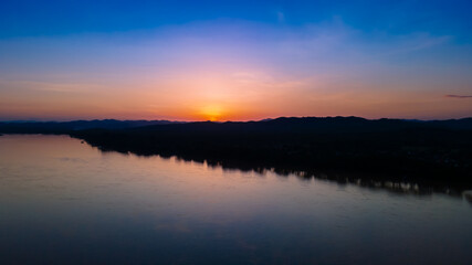 landscape sunset sky over river and silhouette mountain with reflection, sunset at Mekong River and Laos border from Chiangkan, Loei, Thailand