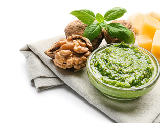Bowl with fresh pesto sauce and ingredients on white background