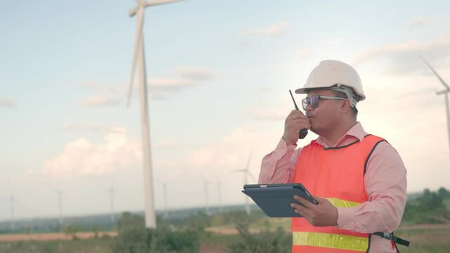 B roll of Asian man engineering are checking the wind turbine and use radio work order to worker on turbine. Engineers and technician concept worker. Maintenance and checklist wind turbines farm.