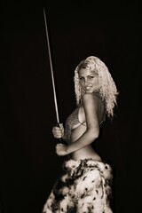 beautiful half-naked girl barbarian with a sword.  and chain mail on the bare chest