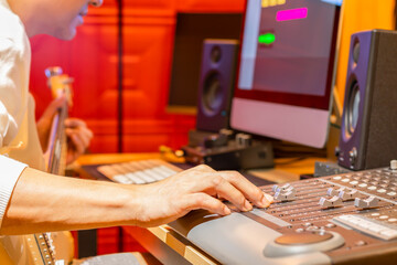 male musician recording electric guitar track on computer, focus on hand. music production concept