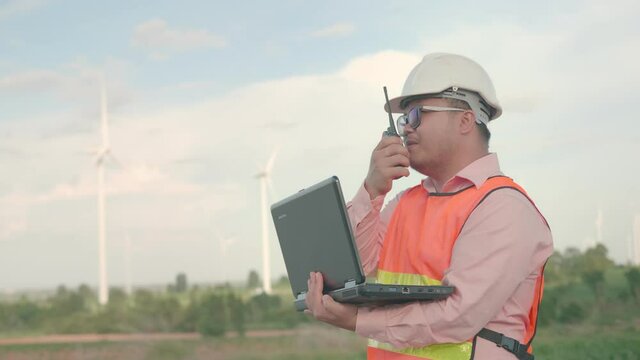 B roll of Asian man engineering are checking the wind turbine and use radio work order to worker on turbine. Engineers and technician concept worker. Maintenance and checklist wind turbines farm.