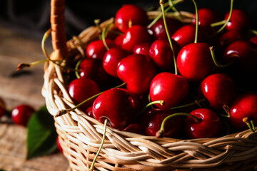 Basket with tasty ripe cherry on wooden background, closeup