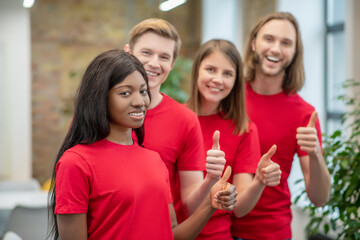 Fototapeta premium African american girl and friends volunteers showing ok gesture