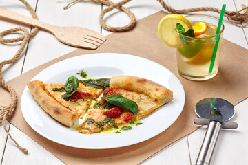 Slices of pizza Margherita with refreshing lemonade with ice