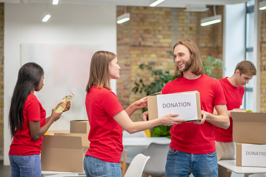 Group of young volunteers packing donations in boxes.