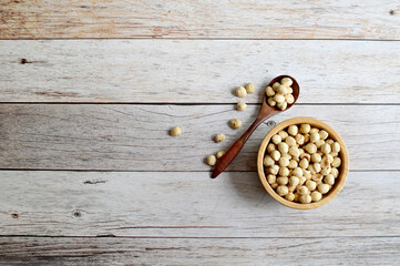 Top Views of Hazel nuts  in a wooden bowl and wooden spoon isolated on the wooden background, Healthy Food Concept.