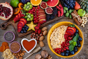 Granola bowl on the table with many berries, fresh fruits and nuts.