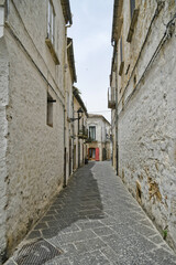 Fototapeta na wymiar Bovino, Italy, 06/23/2021. A narrow street among the old houses of a medieval town with a Mediterranean style in the Puglia region.