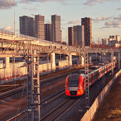 Obraz premium Modern passenger high-speed train on the background of city buildings