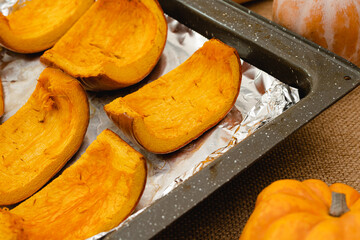 Raw organic pumpkin, butternut, squash, and roasted pumpkin slices close up on kitchen table