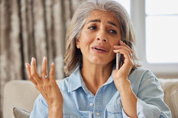 Frustrated Mature Woman Receiving Unwanted Telephone Call At Home