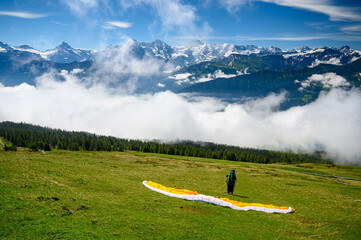 starting paraglider in front of the impressive Bernese Alps