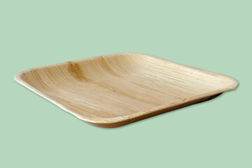 Eco-friendly and sustainable palm leaf plate, isolated on green background. Plastic free, natural...