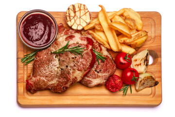 Grilled roated beef steaks, potato and sauce on wooden cutting board