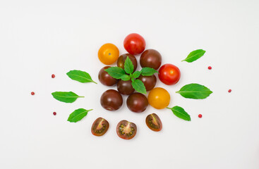 Black red and yellow cherry tomatoes with basil on white background. Helthy eating and agriculture concept.