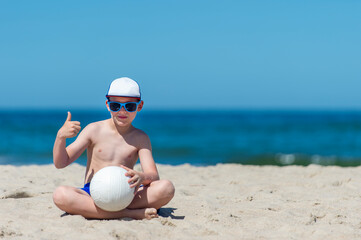 Young boy playing volleyball on beach. Summer sport concept.