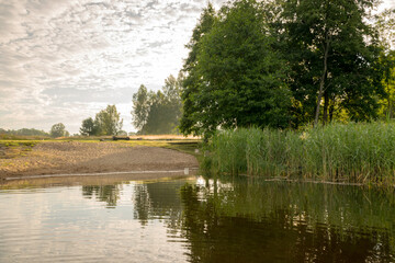 summer morning landscape on the lake, beautiful clouds and wonderful reflections in the lake mirror, summer morning by the water