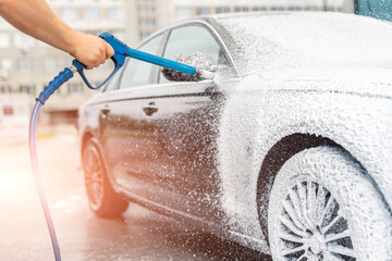 Close-up detail car wash with high pressure water equipment pump at self-service outdoor on bright...