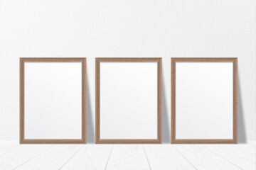 Mockup of three clean white minimalist blank wooden photo frames on the floor with shadow effect