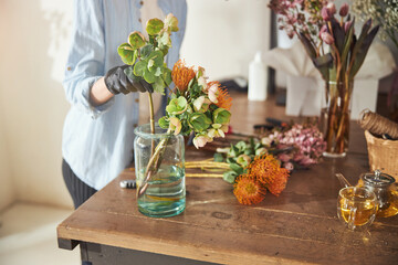 Floral designer working on a flower arrangement - obrazy, fototapety, plakaty