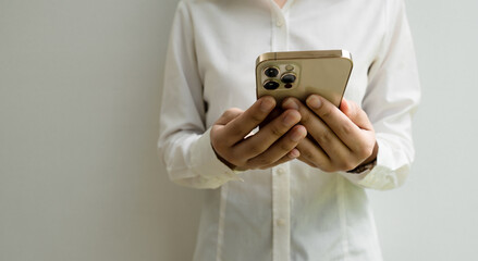 Close up of woman using mobile smart phone on a gray background