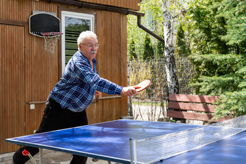 Senior mature grey caucasian old male person making strong ball shot playing ping pong table tennis...