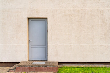Grey metallic door in wall of industrial building