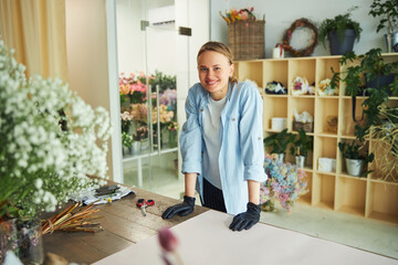 Joyous attractive floral designer posing for the camera at work