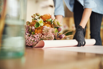 Woman in nitrile gloves working on a spring floral arrangement