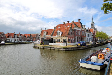 Fototapeta na wymiar The historical center of Makkum, Friesland, Netherlands, with historical houses, canals and boats