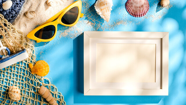 summer sunlight concept.blank picture frame card on beach accessory on blue sea background