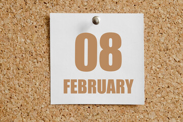 february 08. 08th day of the month, calendar date.White calendar sheet attached to brown cork board.Winter month, day of the year concept
