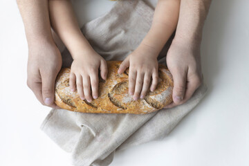 Obraz na płótnie Canvas Top view of bread in the hands of father and son