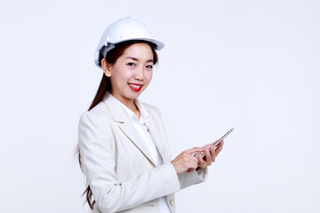 Side view of young Asian female construction architect in office suit and hardhat checking information on mobile phone against white background