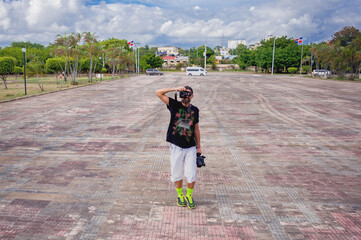 photographer is taking picture of a photogradher full face in twilight on the wide open empty square in Dominican Republic