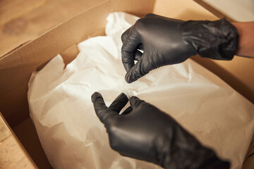 Worker in nitrile gloves preparing the package for shipping - obrazy, fototapety, plakaty