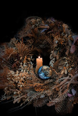 burning candle, symbolic moon, dry autumn leaves on dark natural background. old pagan, Wiccan,...