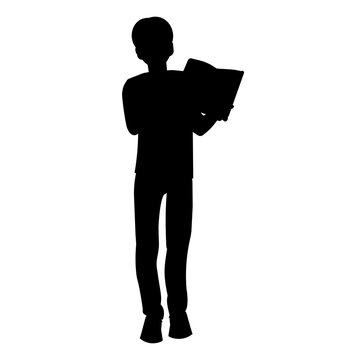 Silhouette of a teenage boy standing with an open book in his hands