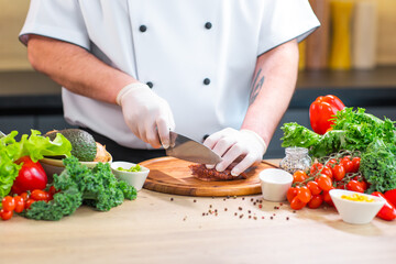 Young chef is cutting octopus in a modern kitchen. The man prepares food at home. Cooking healthy and tasty food.