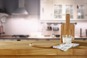 Fresh milk in glass on wooden table and kitchen interior 
