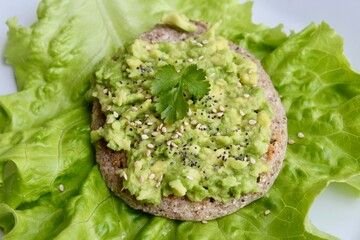 Boiled egg with black seeds on avocado toast made of buckwheat