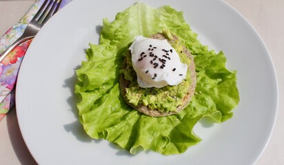 Boiled egg with black seeds on avocado toast made of buckwheat