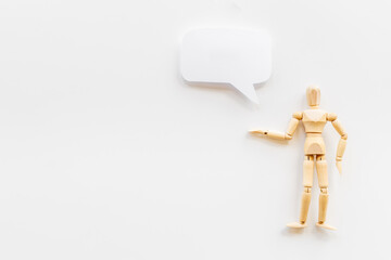 Wooden man figure presenting and showing on speech bubble banner